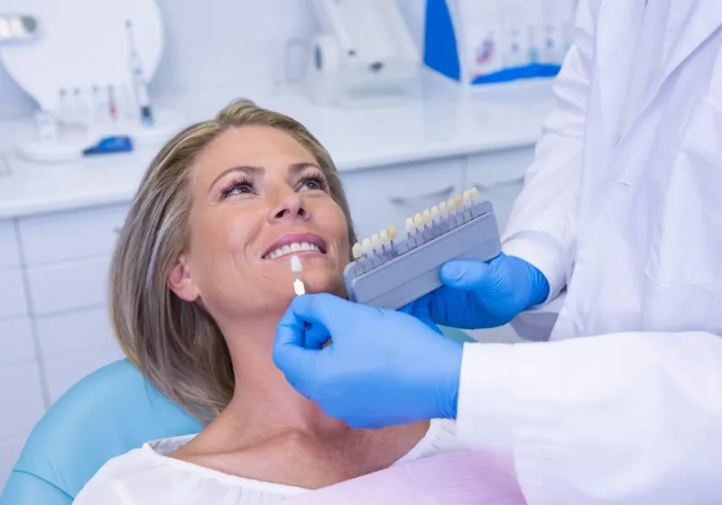 Dentista preparando um procedimento estético no sorriso de uma paciente