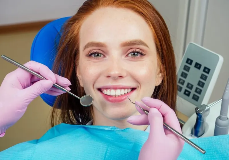 Paciente sorrindo na cadeira do consultório da OdontoSin